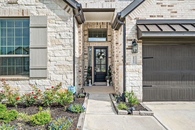 view of exterior entry featuring an attached garage and stone siding