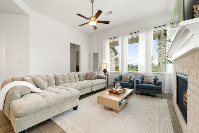living area with wood finished floors, a fireplace, and ceiling fan