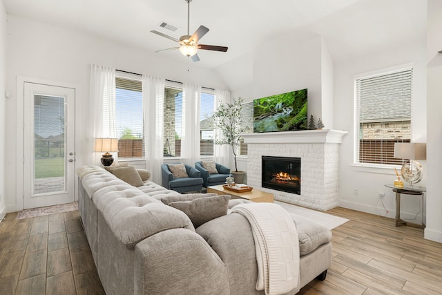 living room with ceiling fan, a fireplace, baseboards, wood finished floors, and lofted ceiling