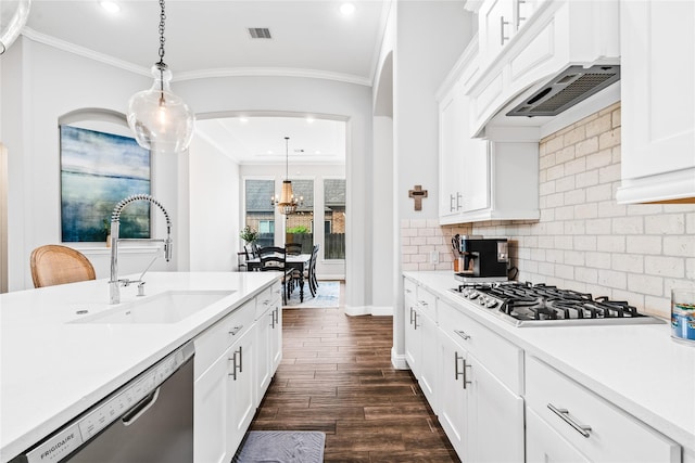 kitchen with ornamental molding, visible vents, a sink, dark wood-type flooring, and appliances with stainless steel finishes