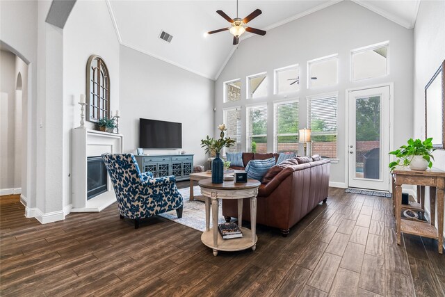 living room featuring a ceiling fan, baseboards, visible vents, dark wood-type flooring, and arched walkways