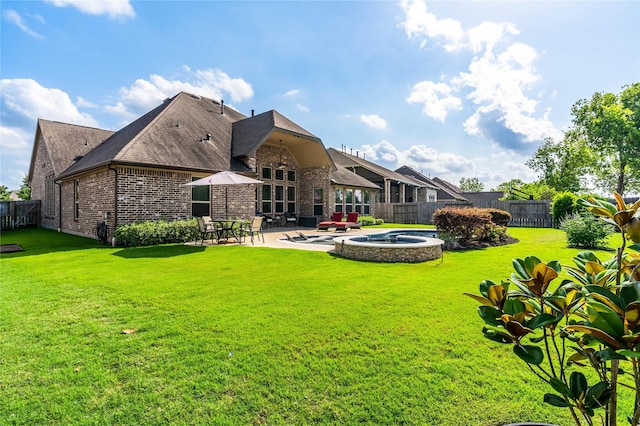 back of property with brick siding, a lawn, a fenced backyard, and a patio