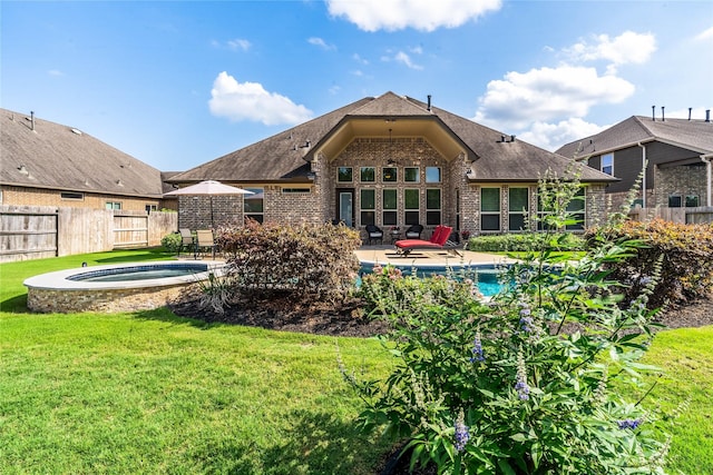 rear view of house featuring a hot tub, fence, a yard, and brick siding