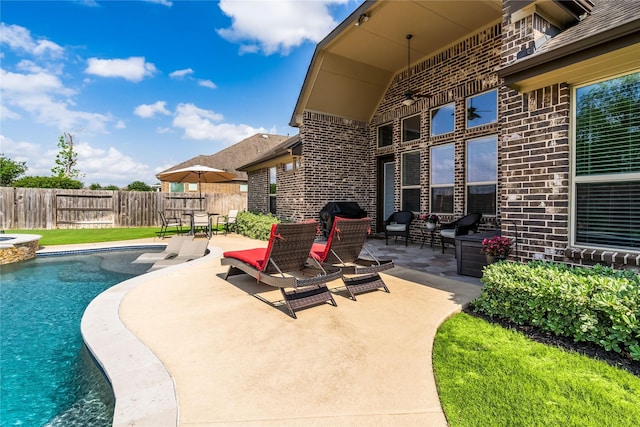 view of pool featuring a patio area, a pool with connected hot tub, ceiling fan, and fence