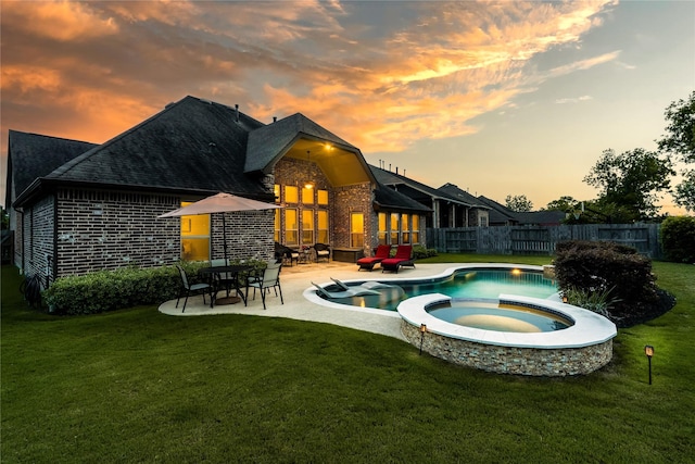 back of house featuring a yard, brick siding, and fence
