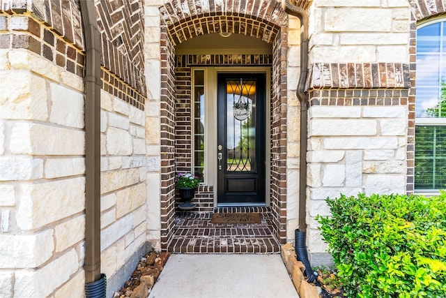 doorway to property with brick siding and stone siding