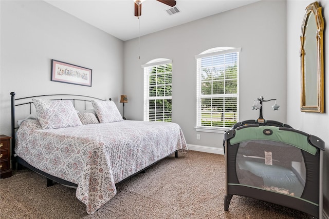 carpeted bedroom featuring baseboards, a ceiling fan, and visible vents