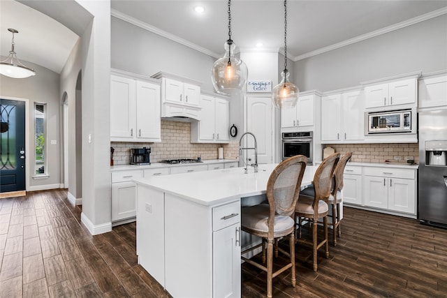 kitchen with a sink, stainless steel appliances, light countertops, and dark wood-type flooring