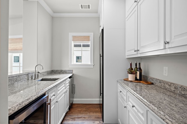 5412 Jackson St, Houston, TX 77004 - kitchen featuring a sink, wine cooler, ornamental molding, plenty of natural light, and white cabinets