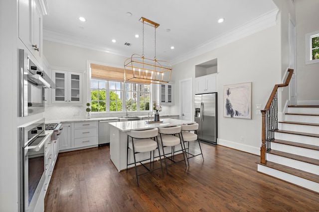 5412 Jackson St, Houston, TX 77004 - kitchen featuring stainless steel appliances, plenty of natural light, a kitchen island, a breakfast bar area, and ornamental molding