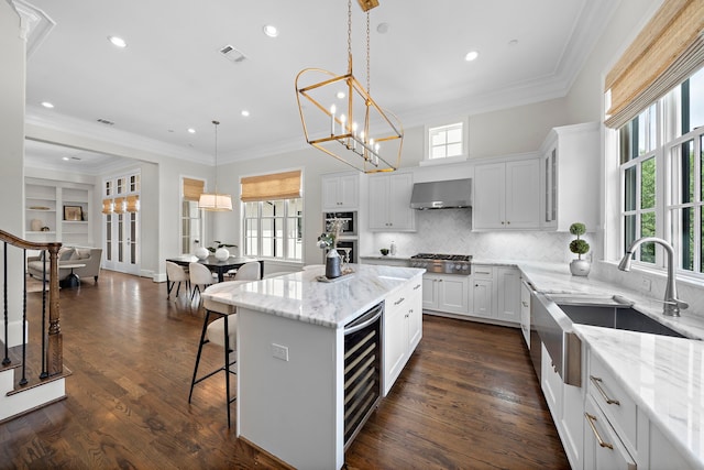 5412 Jackson St, Houston, TX 77004 - kitchen featuring exhaust hood, beverage cooler, a sink, healthy amount of natural light, and ornamental molding