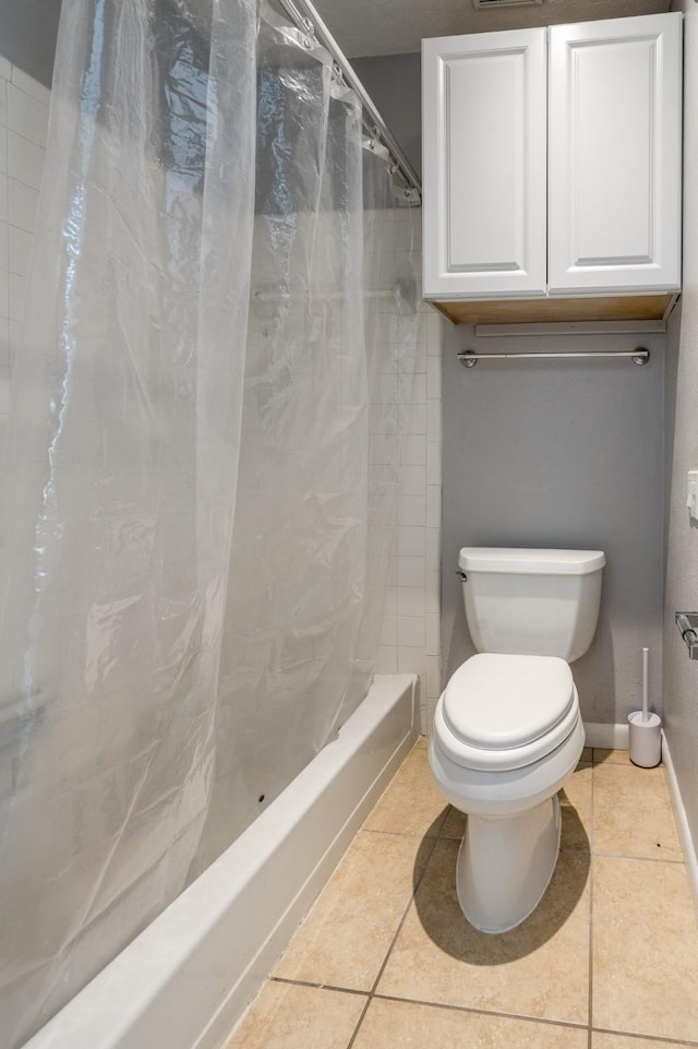 bathroom featuring toilet, tile patterned flooring, and baseboards