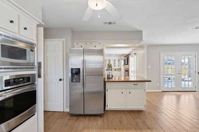 6615 Ampton Dr, Spring, TX 77379 - kitchen with appliances with stainless steel finishes, light wood-style flooring, white cabinets, and french doors