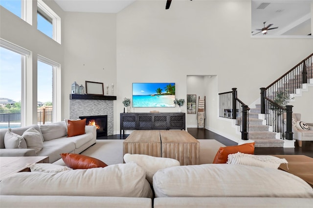 437 Ripple Edge Ct, Katy, TX 77493 - living room with ceiling fan, a towering ceiling, wood finished floors, stairs, and a fireplace