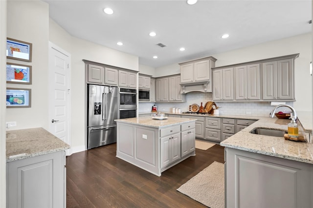 437 Ripple Edge Ct, Katy, TX 77493 - kitchen featuring stainless steel appliances, gray cabinets, a sink, dark wood-style flooring, and light stone counters