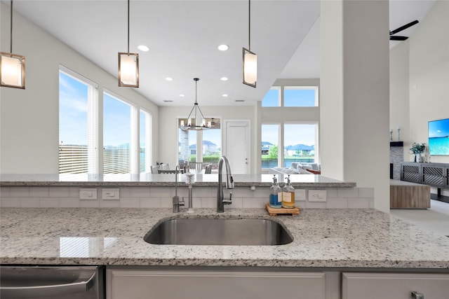 437 Ripple Edge Ct, Katy, TX 77493 - kitchen with a sink, dishwasher, light stone counters, a chandelier, and recessed lighting