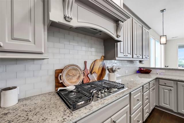 437 Ripple Edge Ct, Katy, TX 77493 - kitchen featuring stainless steel gas stovetop, tasteful backsplash, hanging light fixtures, and light stone countertops