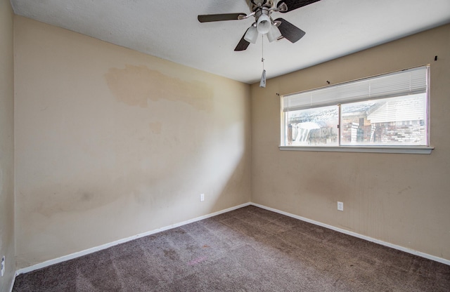 carpeted empty room featuring baseboards and ceiling fan