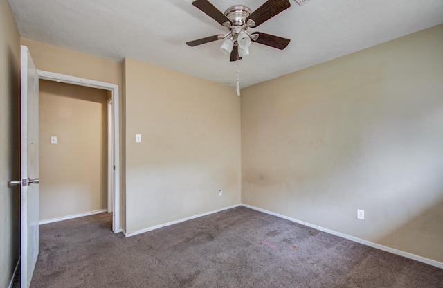 carpeted spare room with baseboards and a ceiling fan