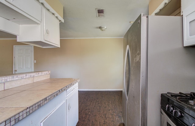 kitchen featuring freestanding refrigerator, dark wood-type flooring, visible vents, and white cabinets