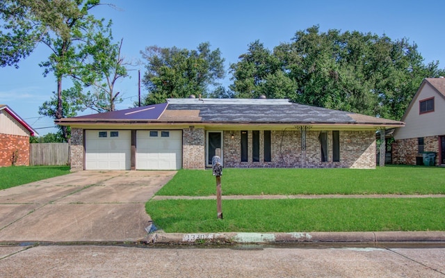 ranch-style house with concrete driveway, an attached garage, a front lawn, and brick siding