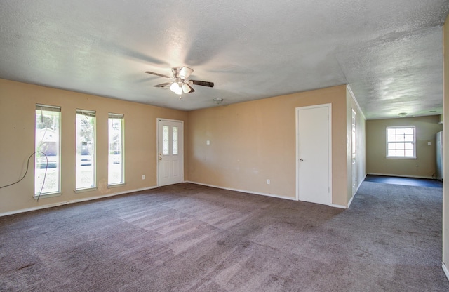 carpeted empty room featuring a textured ceiling, baseboards, and a ceiling fan