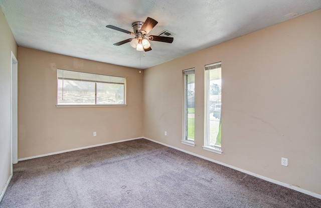 carpeted empty room featuring a ceiling fan, baseboards, visible vents, and a textured ceiling