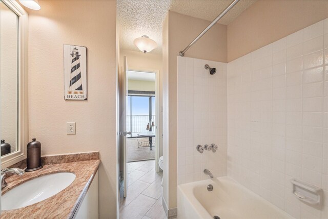 7700 Seawall Blvd Unit 402, Galveston, TX 77551 - full bath with toilet, tile patterned floors, a textured ceiling, vanity, and shower / bathtub combination