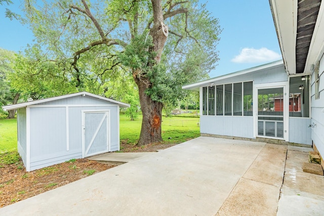 view of patio / terrace with a sunroom, an outdoor structure, and a shed