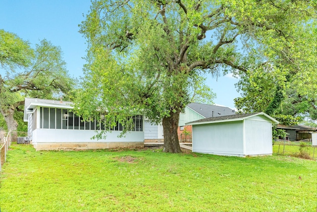rear view of house with a lawn, a sunroom, and fence