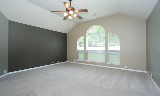 empty room with vaulted ceiling, carpet, visible vents, and a ceiling fan