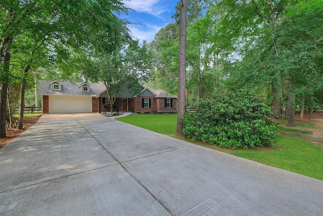 ranch-style house featuring a garage, a front yard, brick siding, and driveway