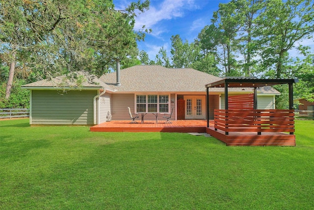 rear view of house featuring fence, roof with shingles, french doors, and a lawn