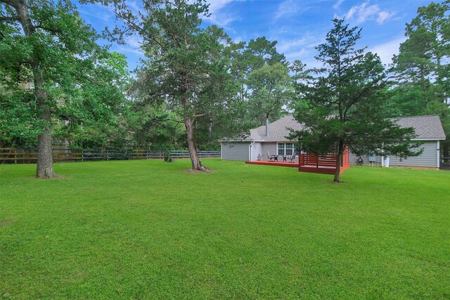 view of yard with a wooden deck and fence