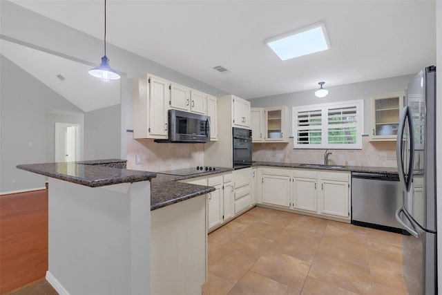 kitchen with a sink, a peninsula, tasteful backsplash, dark stone counters, and black appliances