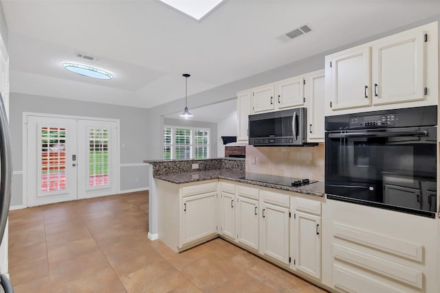 kitchen featuring a peninsula, backsplash, black appliances, and visible vents