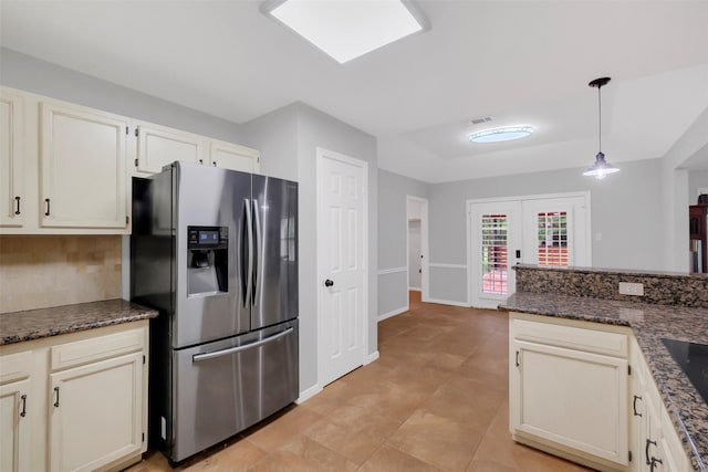 kitchen featuring french doors, light tile patterned floors, hanging light fixtures, visible vents, and stainless steel fridge