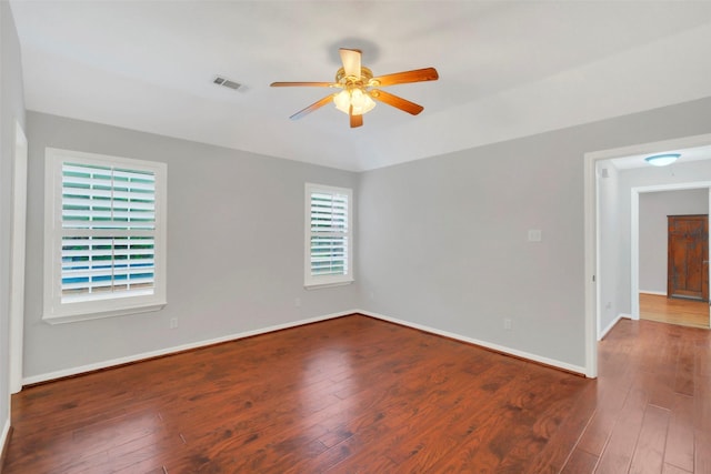 empty room with a ceiling fan, baseboards, wood-type flooring, and visible vents