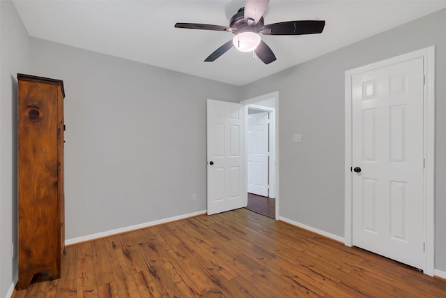 unfurnished bedroom featuring ceiling fan, baseboards, and wood-type flooring