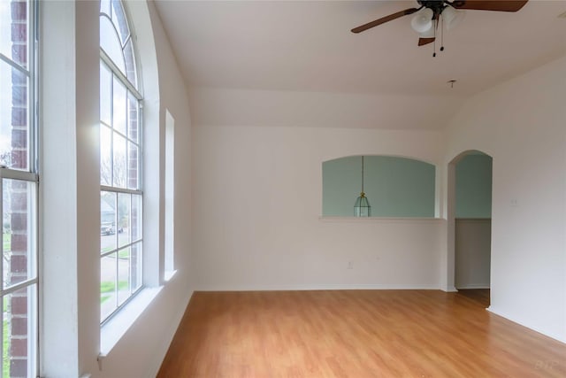 4411 Osage Dr, Baytown, TX 77521 - unfurnished room with light wood finished floors, baseboards, ceiling fan, and arched walkways