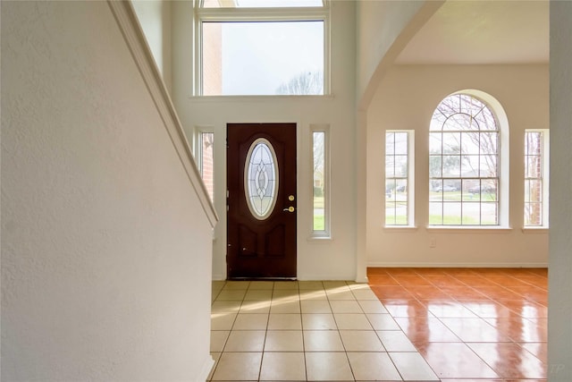 4411 Osage Dr, Baytown, TX 77521 - tiled entrance foyer with arched walkways, baseboards, a high ceiling, and a textured wall