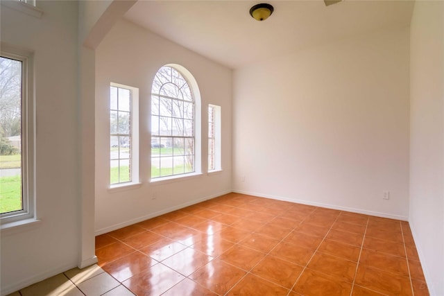 4411 Osage Dr, Baytown, TX 77521 - spare room featuring light tile patterned flooring, arched walkways, and baseboards