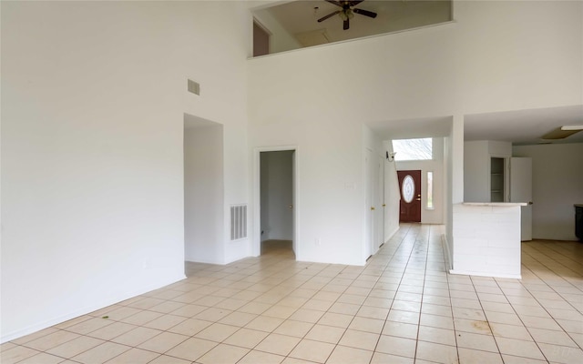 4411 Osage Dr, Baytown, TX 77521 - unfurnished living room with light tile patterned flooring, visible vents, a towering ceiling, and ceiling fan