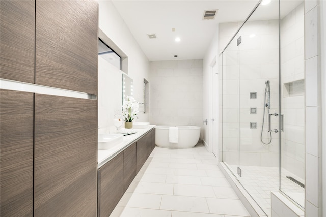 full bathroom with a shower stall, tile patterned flooring, a freestanding tub, and visible vents
