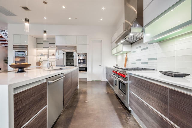 kitchen featuring a sink, wall chimney exhaust hood, modern cabinets, backsplash, and appliances with stainless steel finishes