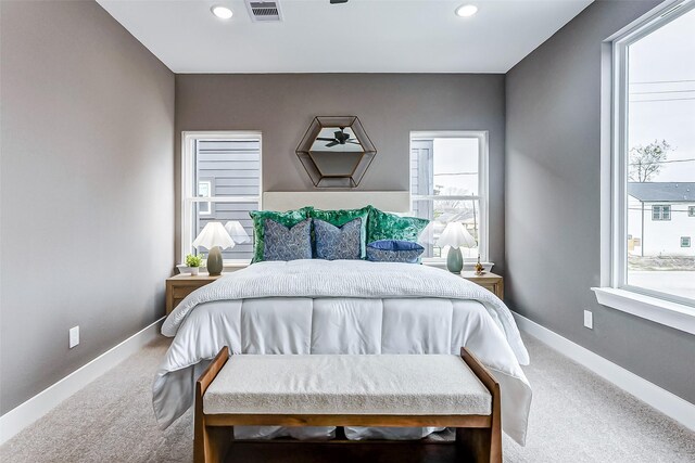 bedroom with recessed lighting, carpet, visible vents, and multiple windows