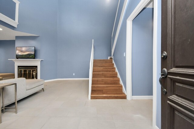 7655 S Braeswood Blvd Unit 10, Houston, TX 77071 - staircase featuring baseboards and a glass covered fireplace