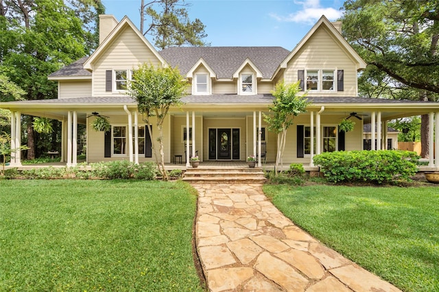 farmhouse inspired home with a ceiling fan, a porch, and a front lawn
