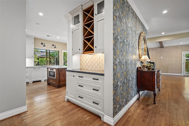 hall featuring baseboards, light wood finished floors, and recessed lighting