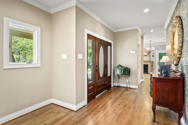 entrance foyer with light wood-type flooring, baseboards, a chandelier, ornamental molding, and recessed lighting